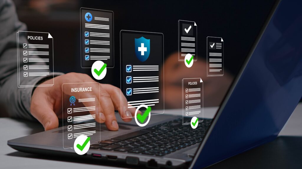 Hand using a laptop with floating policy and insurance documents, illustrating digital compliance management, documentation review, and verified security processes.