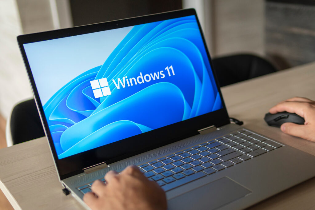 Person using a laptop displaying Windows 11.