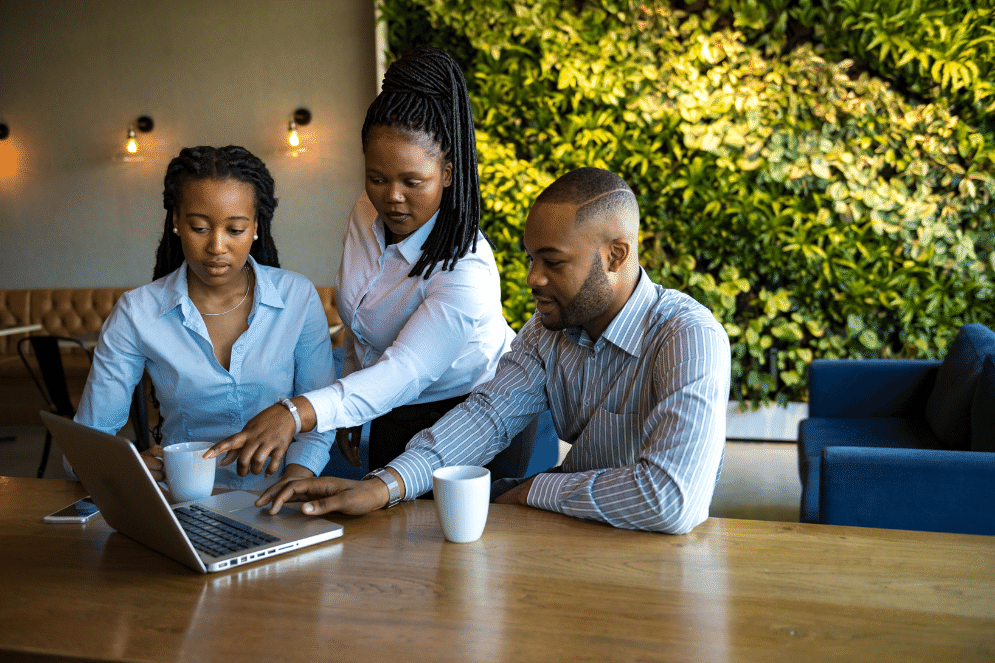 Business people viewing and pointing at a laptop.