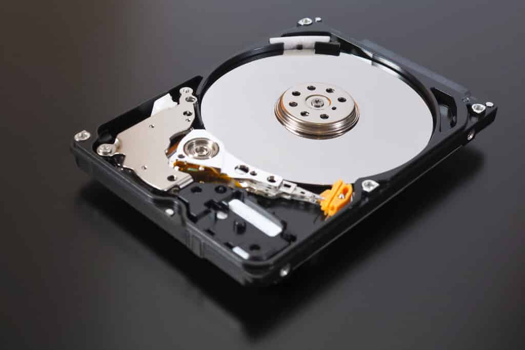 Open hard drive showing platter and actuator arm.