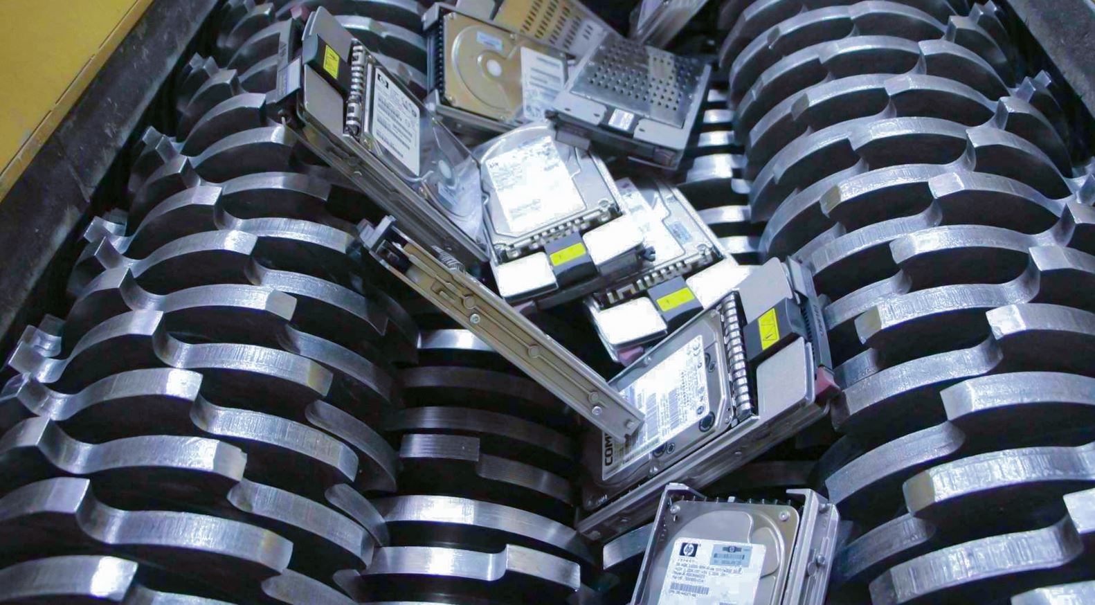 Hard disk drive being destroyed in an industrial shredder for secure physical data destruction.