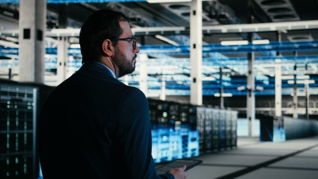 IT professional reviewing data center infrastructure on a tablet to support scalability planning and future capacity needs