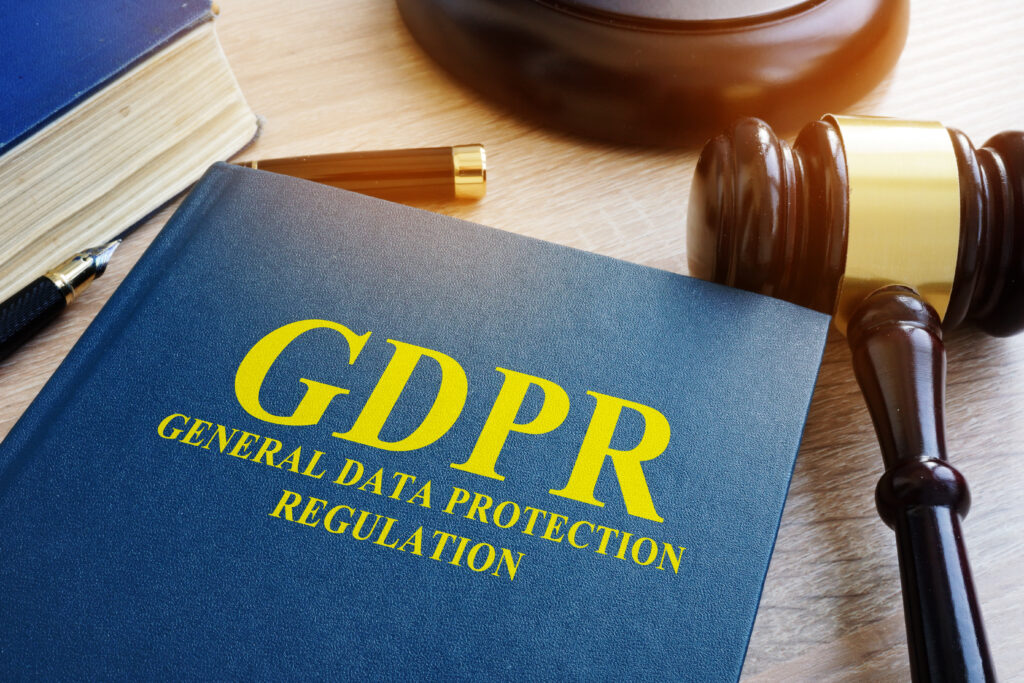 GDPR book with a judge’s gavel and fountain pen on a desk, representing data destruction standards, privacy law, and regulatory compliance.