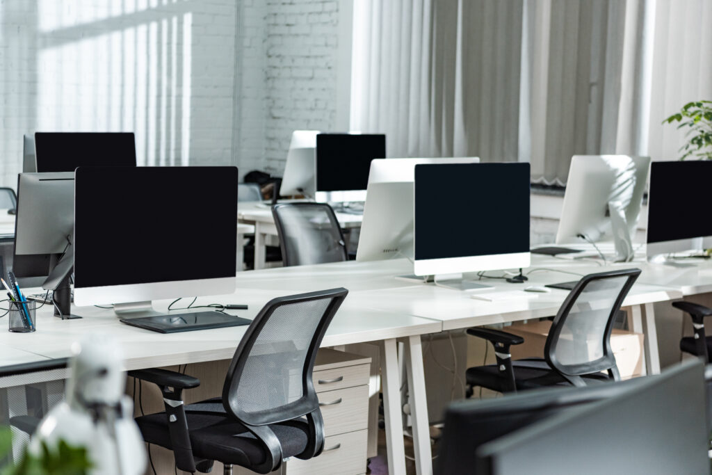 Modern office with computer workstations and empty desks.