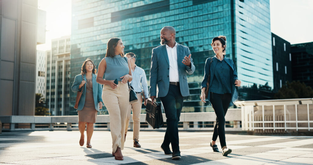 Business professionals walking together in a city plaza, representing the value of having a trusted e-waste recycling partner for your company.