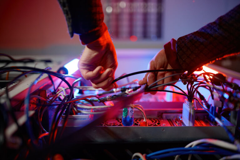 A person is wiring the back of a server rack