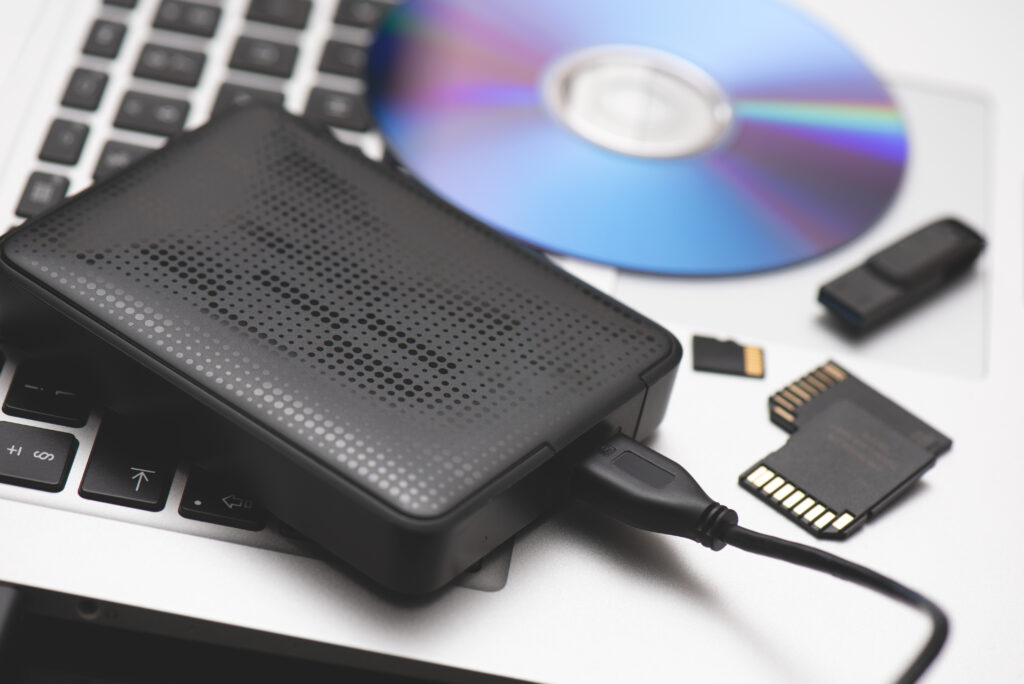 Data storage devices on a laptop, including a hard drive, disc, USB, and SD cards.