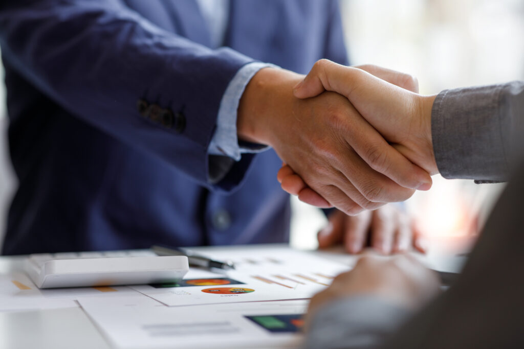 A business professional shaking hands with a representative.