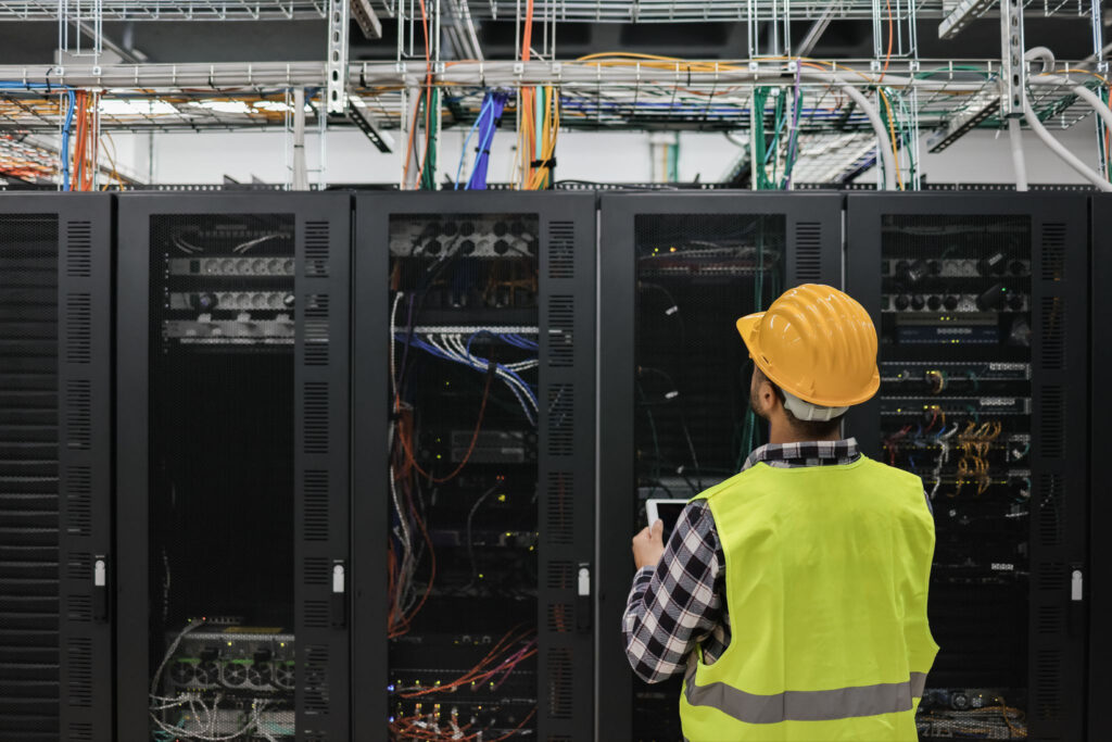 Technician inspecting server racks in a modern data center for equipment recycling