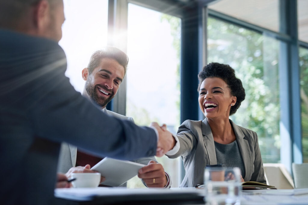 A company leader shaking hands with another business leader, symbolizing partnership.